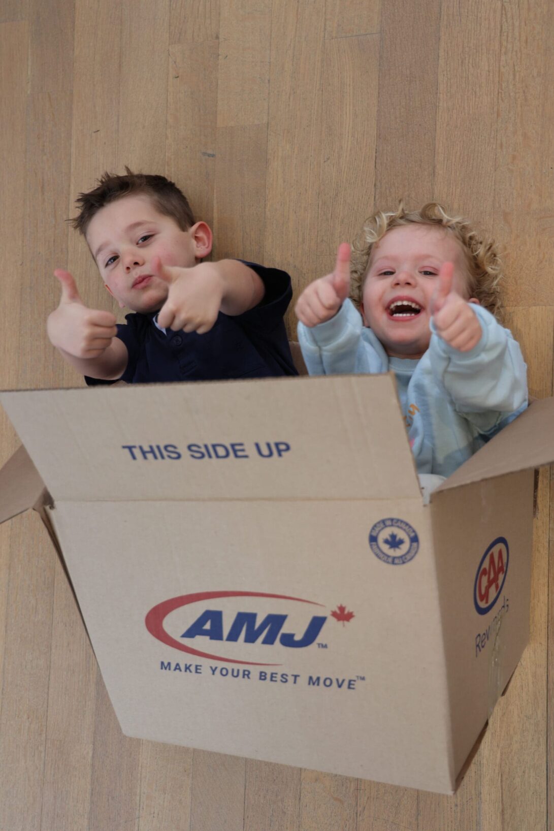 Happy kids playing with AMJ's moving box
